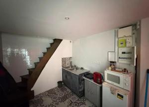 a small kitchen with a sink and a microwave at Maison atypique et confortable in Mamers