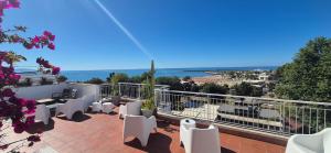 a balcony with white chairs and a view of the ocean at REale Apartments in Terracina