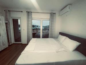 a bedroom with a large white bed with a window at Mia Apartment in Veles +2 photos
