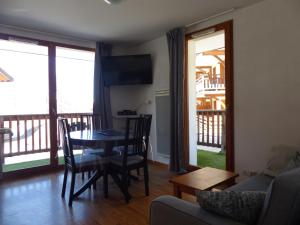 a living room with a table and chairs and a couch at Montagne Les Orres in Les Orres