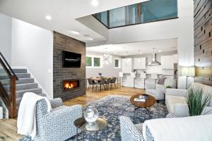 a living room with white furniture and a fireplace at Lakefront Luxury in Mound