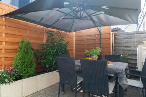 a table and chairs under an umbrella on a patio at Alpenloft Bregenz in Bregenz