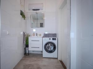 a white laundry room with a washing machine at Alpenloft Bregenz in Bregenz