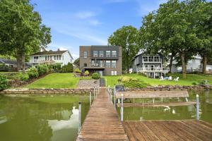 a house with a dock next to a body of water at Lakefront Luxury in Mound