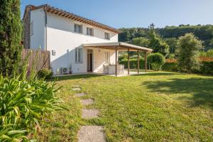 a view of a house with a grass yard at Casa Le Camelie idromassaggio e relax Lucca in Capannori