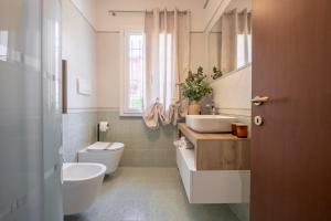 a bathroom with a sink and a toilet and a window at Casa Le Camelie idromassaggio e relax Lucca in Capannori +30 photos