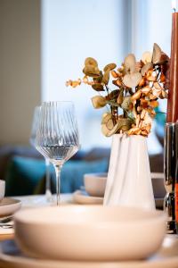 a white vase with flowers in it on a table at Alpenloft Bregenz in Bregenz