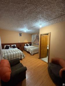 a hotel room with two beds and a couch at Hostal el barranco in Cuenca