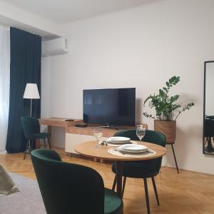 a living room with a table and chairs and a television at Bzs5 in Pécs