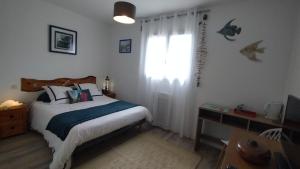 a small bedroom with a bed and a window at L'écrin d'Ar Prajou in Plouénan