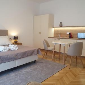 a bedroom with a bed and a table and a kitchen at Bzs5 in Pécs