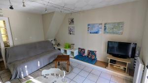 a living room with a couch and a flat screen tv at Gîte les palmiers in Roquebrune-sur-Argens