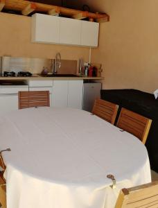 a kitchen with a white table and two chairs at Gîte les palmiers in Roquebrune-sur-Argens