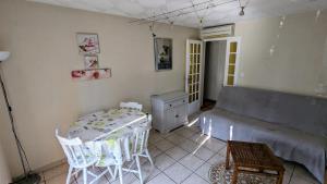 a living room with a table and a couch at Gîte les palmiers in Roquebrune-sur-Argens