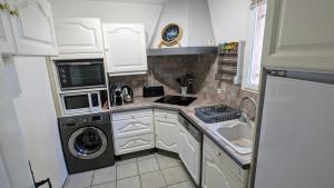 a small kitchen with a washer and dryer at Gîte les palmiers in Roquebrune-sur-Argens