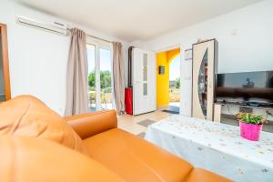 a living room with an orange couch and a table at Casa delle Rondini in Belej