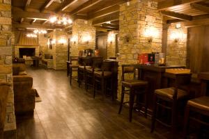 een bar met krukken in een kamer met bakstenen muren bij Thermes Pozar Resort in Kato Loutraki