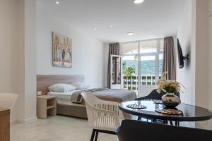 a bedroom with a bed and a table in a room at Apartments Obradović in Neum