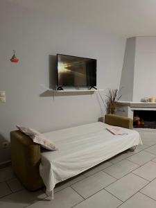 a room with a bed and a flat screen tv on the wall at Vouzianas home in Kefallonia