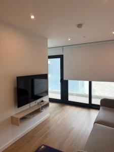 a living room with a flat screen tv on a wall at New CP Victory suites studio sleeps 4 with pool and gym in Gibraltar