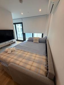 a bedroom with a large bed and a flat screen tv at New CP Victory suites studio sleeps 4 with pool and gym in Gibraltar +31 photos
