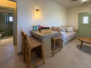 a living room with a couch and a table and chairs at Mikres Cyclades - Koufonisia House in Koufonisia