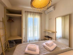 a bedroom with a bed with two towels on it at Mikres Cyclades - Koufonisia House in Koufonisia