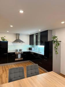 a kitchen with black cabinets and a table and chairs at Haus Haslauer in Strobl