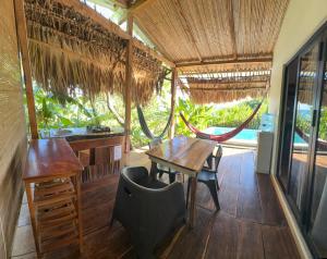 a room with a table and a desk and a hammock at Surf Lodge El Carrizal-Punta Mango in La Periquera