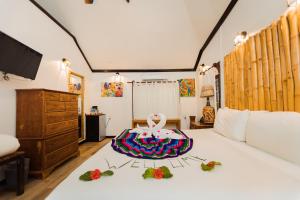 a bedroom with a bed with a swan on it at Falling Leaves Lodge in San Ignacio
