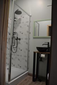 a bathroom with a glass shower with a sink at Hotel Mergera in Mērsrags