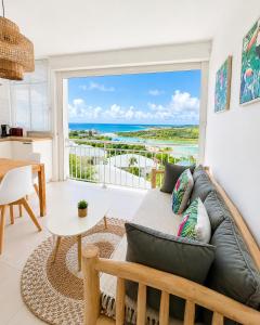 a living room with a couch and a view of the ocean at Studio ALIZEA in Saint Martin