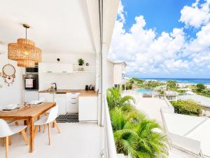 a kitchen and dining room with a view of the ocean at Studio ALIZEA in Saint Martin