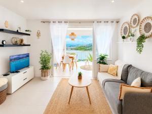 a living room with a couch and a tv and a table at Studio ALIZEA in Saint Martin