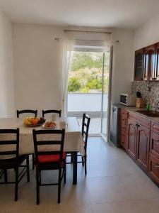 a kitchen with a table with chairs and a table and a window at Croatia Apartman Masa in Senj