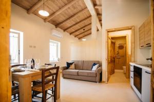 a kitchen and living room with a table and a couch at La Contrà Valpolicella in Fumane