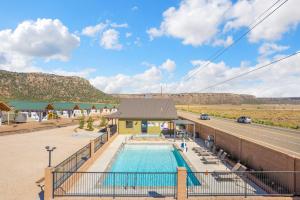 a building with a swimming pool next to a road at Gooseberry Lodges Zion National Park Area in Apple Valley
