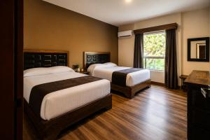 a hotel room with two beds and a window at Hotel Hacienda Concá in Conca +12 photos