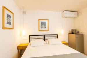 a bedroom with a white bed and a refrigerator at Villa Four Winds II in Dubrovnik