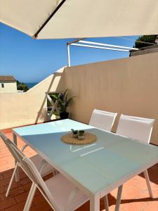 a blue table and chairs on a patio with an umbrella at Hoyo 12 Islantilla in Huelva