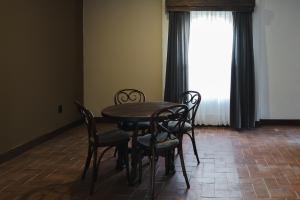a table and chairs in a room with a window at Hotel Hacienda Concá in Conca