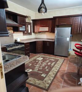 a kitchen with wooden cabinets and a stainless steel refrigerator at Sunset Mirage House in Giza