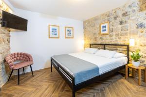 a bedroom with a bed and a chair at Villa Four Winds II in Dubrovnik