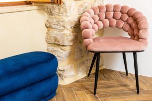 a pink chair sitting next to a stone wall at Villa Four Winds II in Dubrovnik