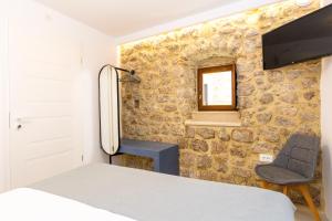a small bedroom with a bed and a chair at Villa Four Winds II in Dubrovnik