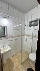 a bathroom with a shower and a toilet and a sink at Hostel Peter Pan in Puerto Iguazú +12 photos