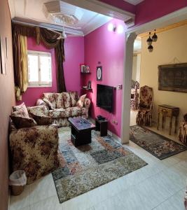 a living room with a couch and a tv at Sunset Mirage House in Giza