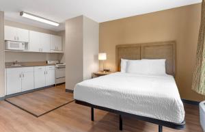 a bedroom with a large bed and a kitchen at Extended Stay America Suites - Fort Worth - Fossil Creek in Fort Worth