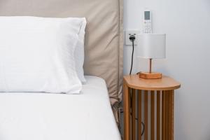 a bed with a white pillow and a table with a lamp at Mandrakia Living House in Mandrakia +19 photos