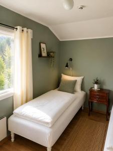 a bed in a room with a window at Hovstø Hytter & Rom in Seljord